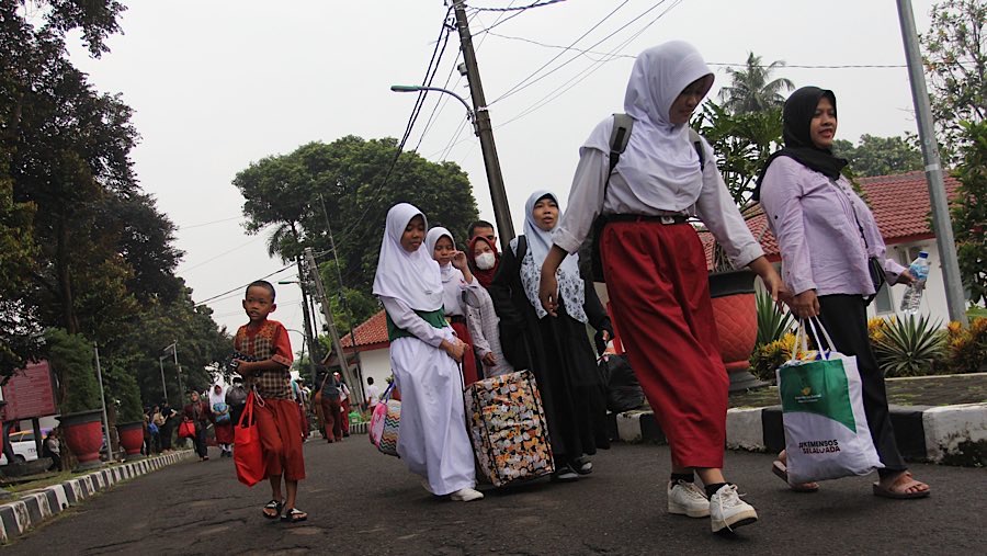 Siswa diantar orang tua tiba di Sekolah Rakyat Menengah Pertama (SRMP) Sentra Handayani, Jakarta, Senin (14/7/2025). (Bloomberg Technoz/Andrean K)