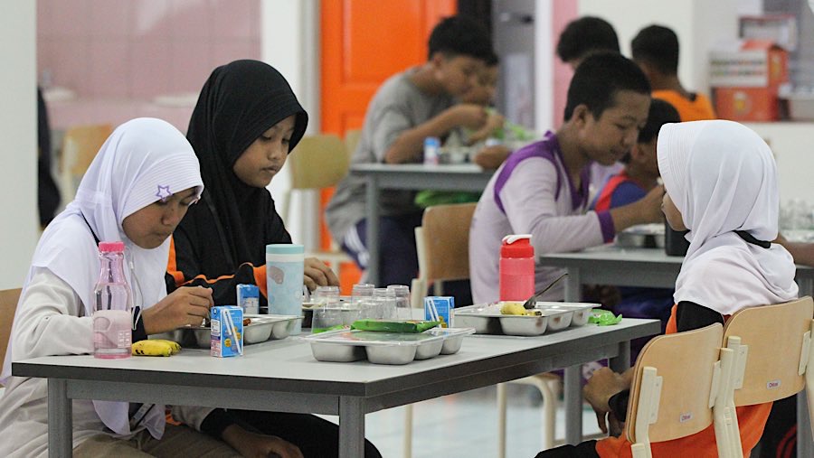 Siswa makan siang bersama di Sekolah Rakyat Menengah Pertama (SRMP) Sentra Handayani, Jakarta, Senin (14/7/2025). (Bloomberg Technoz/Andrean K)
