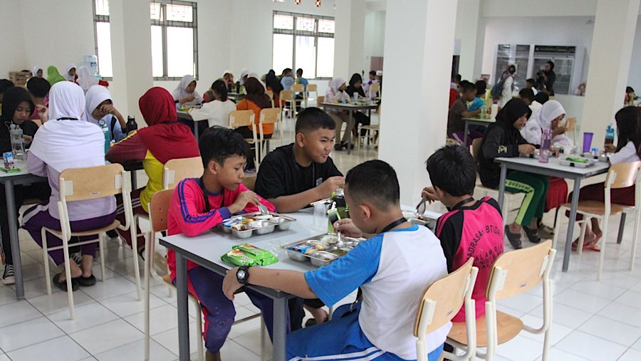 Siswa makan siang di Sekolah Rakyat Menengah Pertama (SRMP) Sentra Handayani, Jakarta, Senin (14/7/2025). (Bloomberg Technoz/Andrean Kristianto)