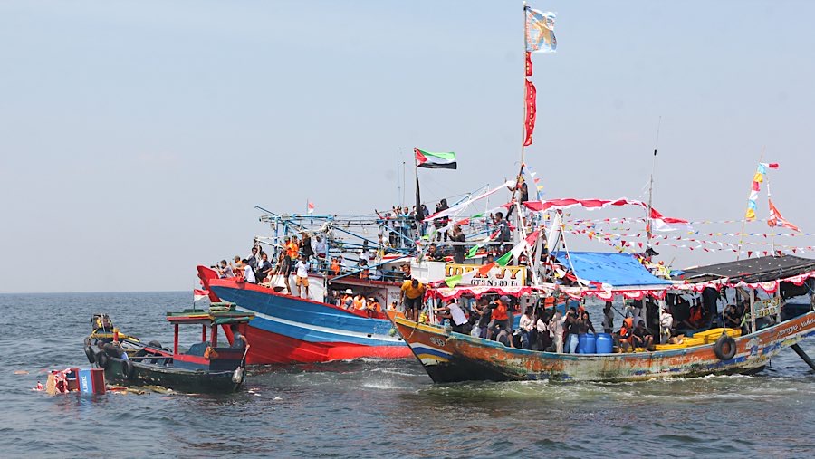 Ada juga yang memandikan diri dan menyiram kapalnya dengan air laut di lokasi pelarungan. (Bloomberg Technoz/Andrean Kristianto) 