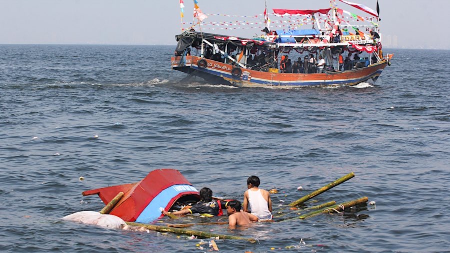 Mereka yang menyeburkan diri mengambil berbagai sesaji termasuk uang yang telah dilarung ke tengah laut.
 (Bloomberg Technoz/Andrean Kristianto) 