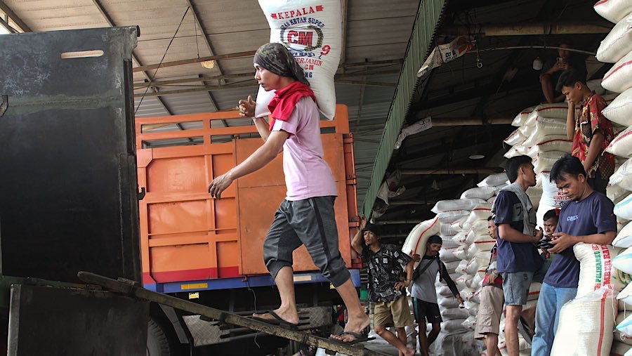 Pekerja mengangkut karung beras di Pasar Induk Beras Cipinang, Jakarta, Jumat (25/7/2025). (Bloomberg Technoz/Andrean Kristianto)