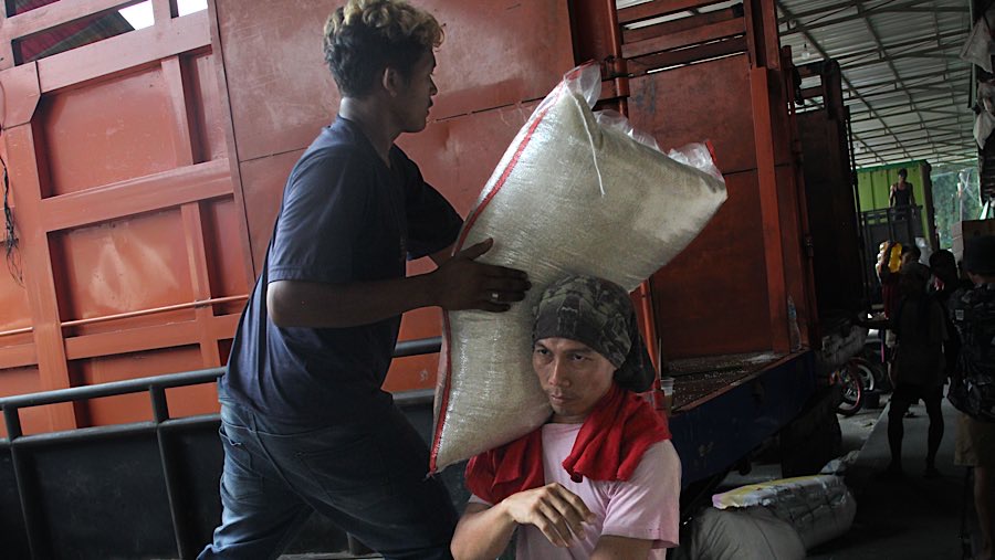 Pekerja mengangkut karung beras di Pasar Induk Beras Cipinang, Jakarta, Jumat (25/7/2025). (Bloomberg Technoz/Andrean Kristianto)