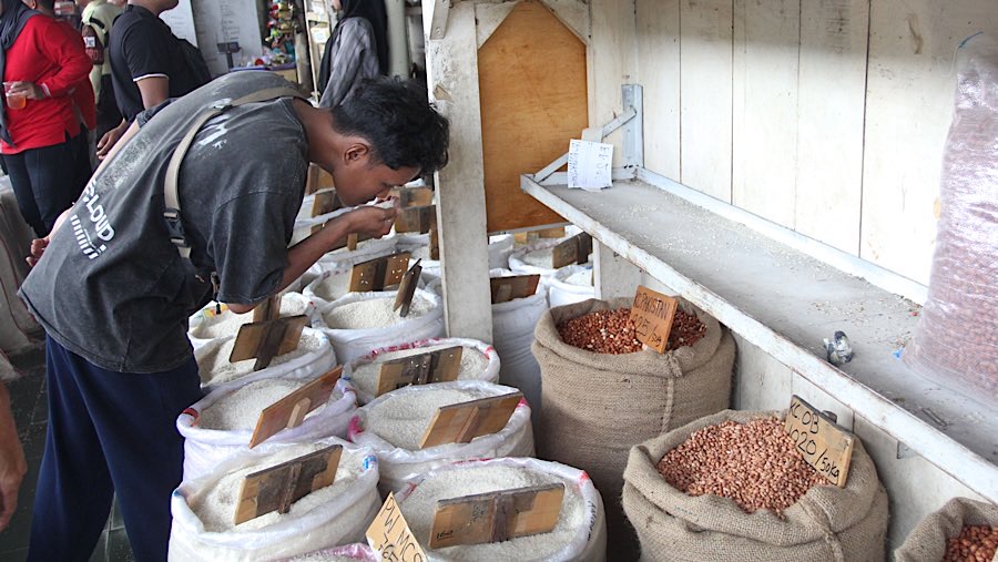 Warga memiih beras yang dijual di Pasar Induk Beras Cipinang, Jakarta, Jumat (25/7/2025). (Bloomberg Technoz/Andrean Kristianto)