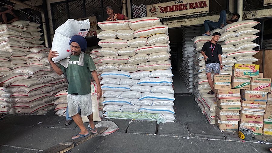 Pekerja mengangkut karung beras di Pasar Induk Beras Cipinang, Jakarta, Jumat (25/7/2025). (Bloomberg Technoz/Andrean Kristianto)
