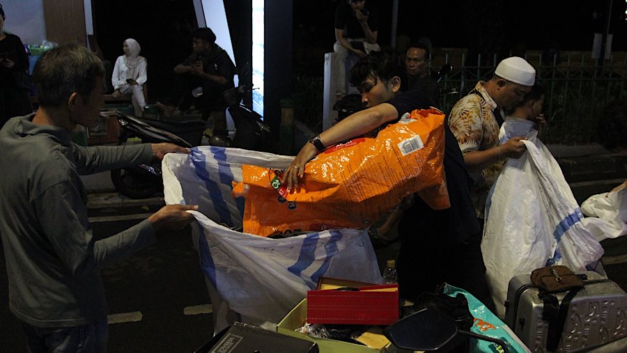 Sejumlah pedagang terlihat sibuk menyelamatkan barang dagangan mereka.  (Bloomberg Technoz/Andrean Kristianto)