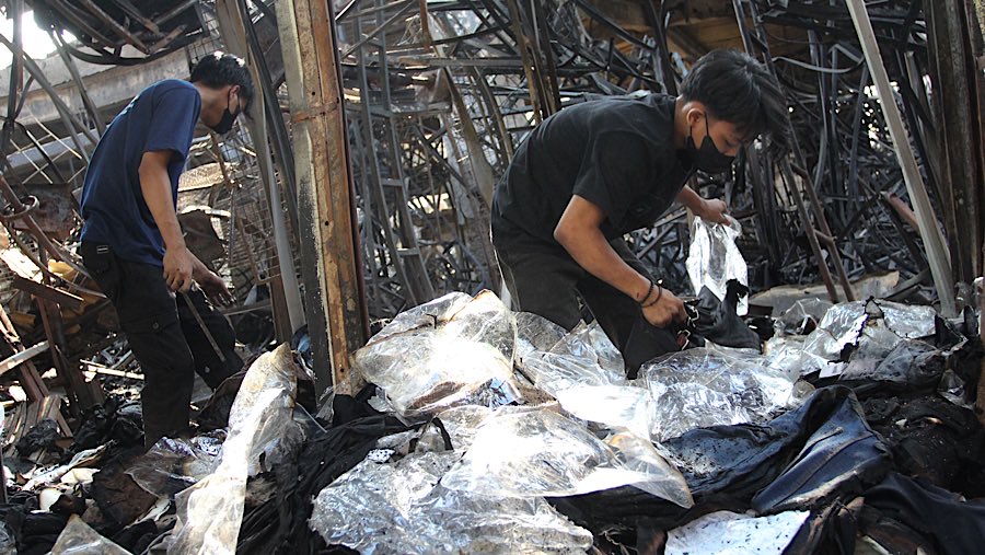 Pemilk kios mencari barang dagangannya diantara puing dan sisa-sisa kebakaran semalam. (Bloomberg Technoz/Andrean Kristianto)