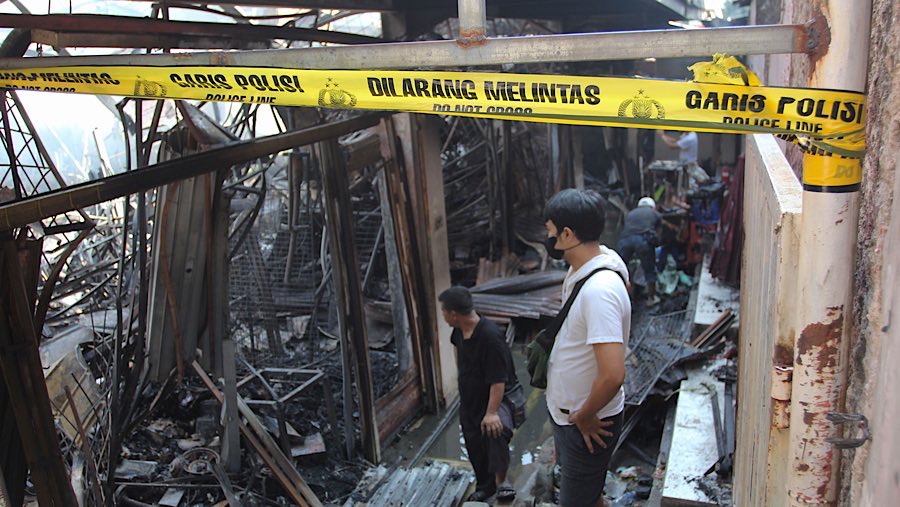 Pedagang mencari sisa-sisa barang usai kebakaran di Pasar Taman Puring, Selasa (29/7/2025). (Bloomberg Technoz/Andrean Kristianto)