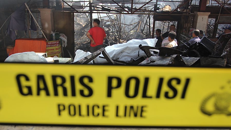 Usai api yang membakar kios Pasar Taman Puring, garis polisi dipasang di lokasi kejadian. (Bloomberg Technoz/Andrean Kristianto)