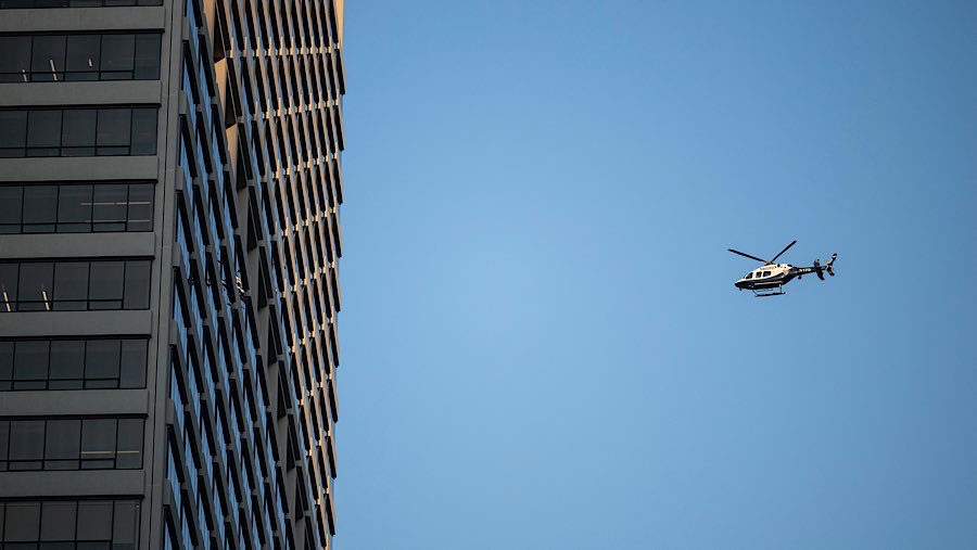 Akibat insiden tersebut puluhan mobil polisi menutup area tersebut dan helikopter terlihat di atasnya. (Victor J. Blue/Bloomberg)