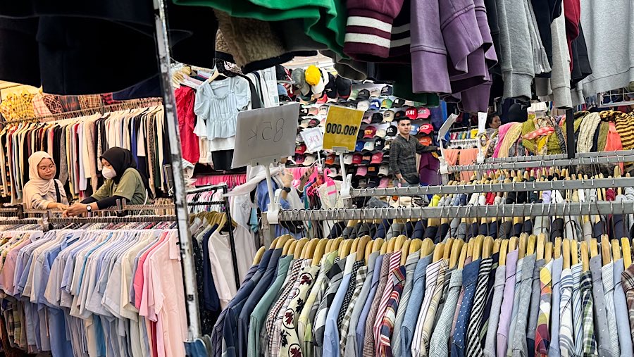 Calon pembeli melihat pakaian bekas (Thrifting) yang dijual di Pasar Baru, Jakarta, Kamis (31/7/2025). (Bloomberg Technoz/Andrean Kristianrto)
