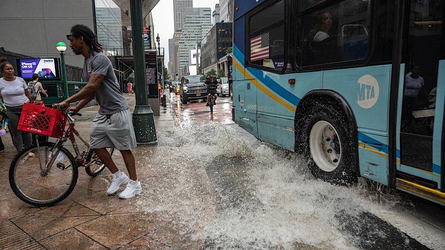 Warga berjalan saat hujan badai di New York, AS, Kamis (31/7/2025). (Victor J. Blue/Bloomberg)