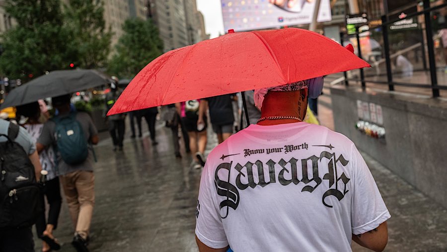 Warga berjalan saat hujan badai di New York, AS, Kamis (31/7/2025). (Victor J. Blue/Bloomberg)