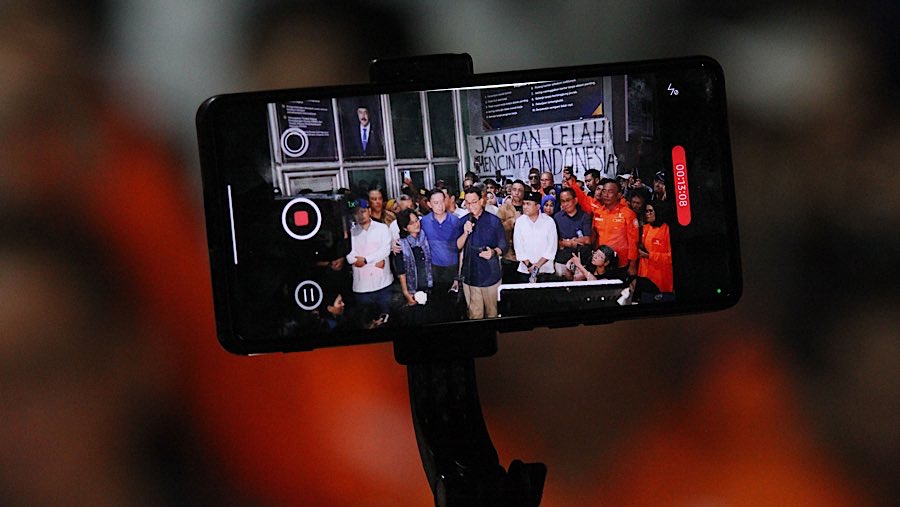 Beberapa pendukung dan awak media mendokumentasikan momen keluarnya Tom Lembong dari Rutan Cipinang. (Bloomberg Technoz/Andrean Kristianto)