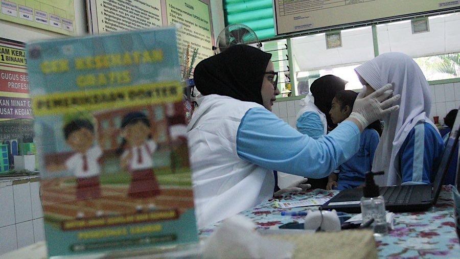 Petugas Puskesmas melakukan Cek Kesehatan Gratis (CKG) Sekolah di SDN 02 Cideng, Jakarta, Senin (4/8/2025). (Bloomberg Technoz/Andrean Kristianto)