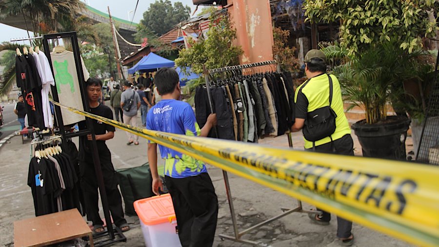 Mereka berdagang di dalam area yang masih dipasangi garis polisi.  (Bloomberg Technoz/Andrean Kristianto)