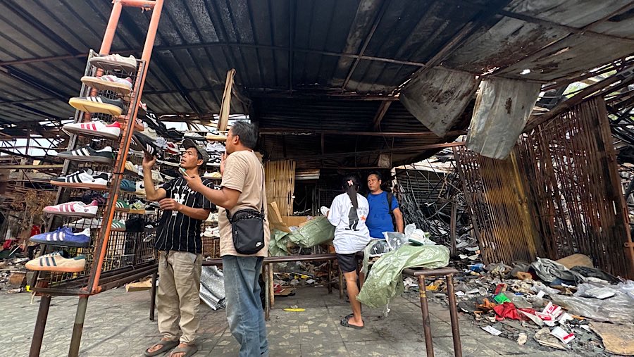 Pedagang menata dagangan pascakebakaran di halaman Pasar Taman Puring, Jakarta, Senin (4/8/2025). (Bloomberg Technoz/Andrean Kristianto)