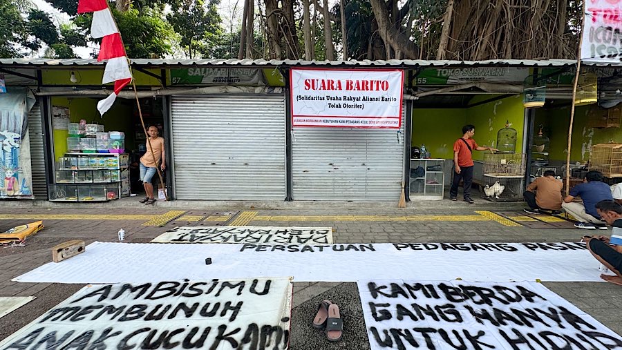 Pedagang memasang spanduk untuk menolak relokasi di Pasar Burung Barito, Jakarta, Selasa (5/8/2025). (Bloomberg Technoz/Andrean Kristianto)