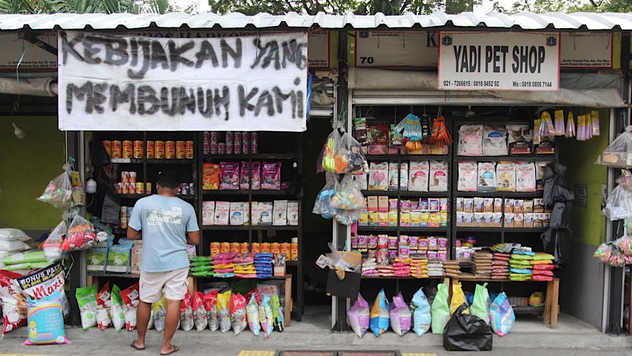 Pedagang memasang spanduk untuk menolak relokasi di Pasar Burung Barito, Jakarta, Selasa (5/8/2025). (Bloomberg Technoz/Andrean Kristianto)