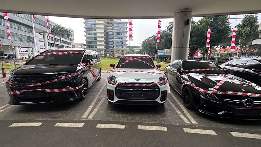 Sejumlah mobil sitaan dari tersangka Mohammad Riza Chalid terparkir di Kejagung, Selasa (5/8/2025). (Bloomberg Technoz/Andrean Kristianto)
