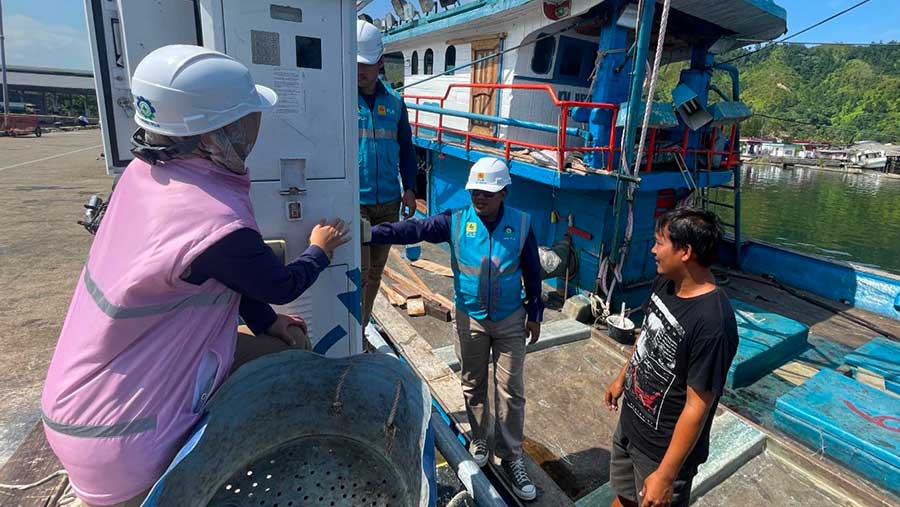 Petugas PLN ketika sedang berbincang dengan salah seorang pemilik kapal ikan yang sedang menggunakan ALMA. (Dok. PLN)