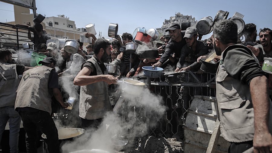 Warga Palestina membagikan makanan gratis dari dapur amal di Kota Gaza, Gaza, Senin (4/8/2025). (Ahmad Salem/Bloomberg)