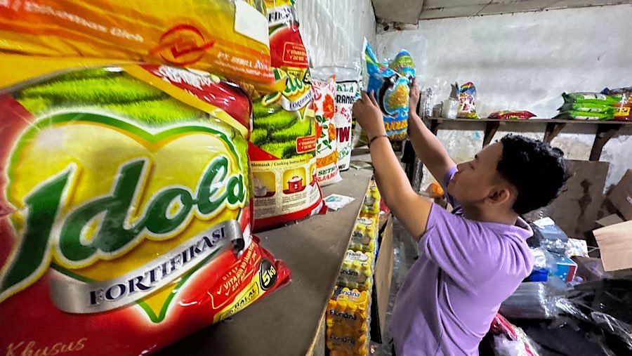 Calon pembeli memilih beras di salah satu warung sembako di Kawasan Jati Padang, Jakarta, Selasa (12/8/2025) (Bloomberg Technoz/Andrean Kristianto)
