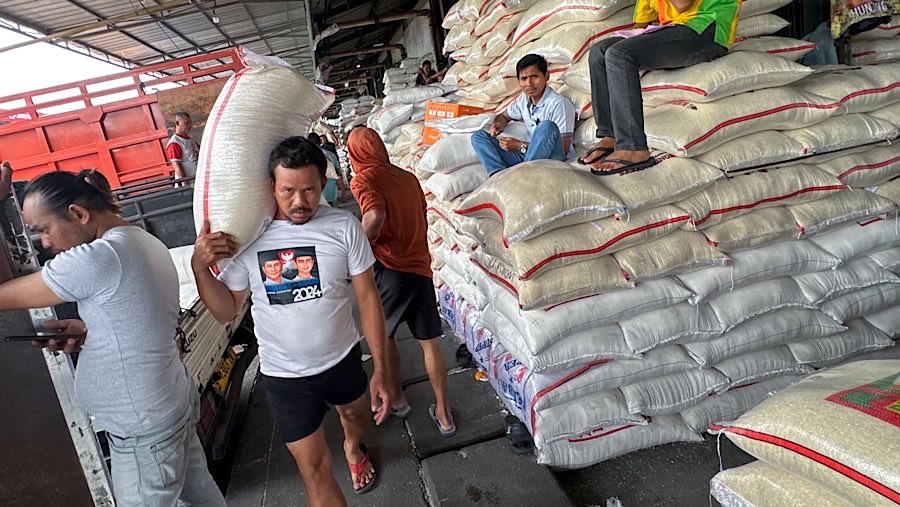 Pekerja memanggul karung beras di Pasar Induk Beras, Cipinang, Jakarta, Rabu (14/8/2025). (Bloomberg Technoz/Andrean Kristianto)