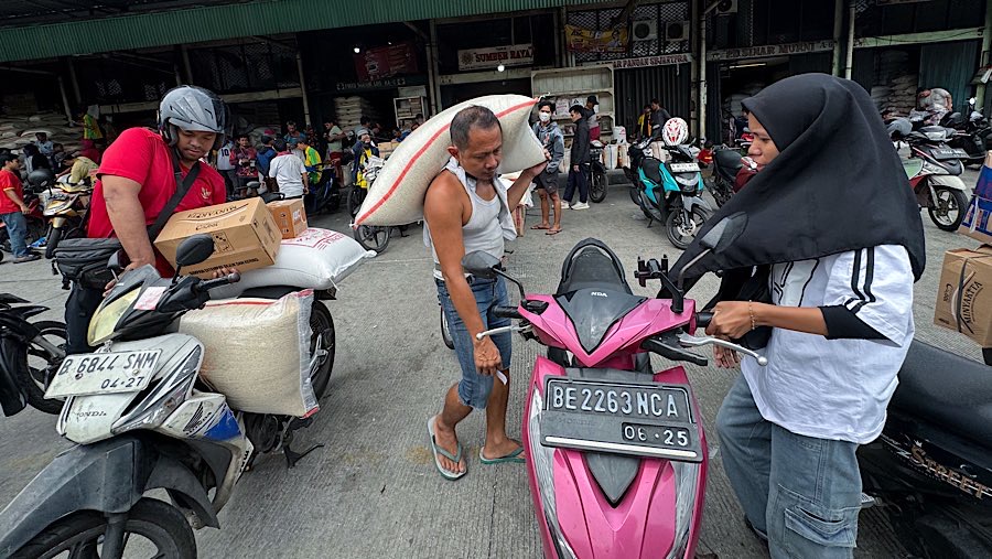 Pekerja memanggul karung beras di Pasar Induk Beras, Cipinang, Jakarta, Rabu (14/8/2025). (Bloomberg Technoz/Andrean Kristianto)