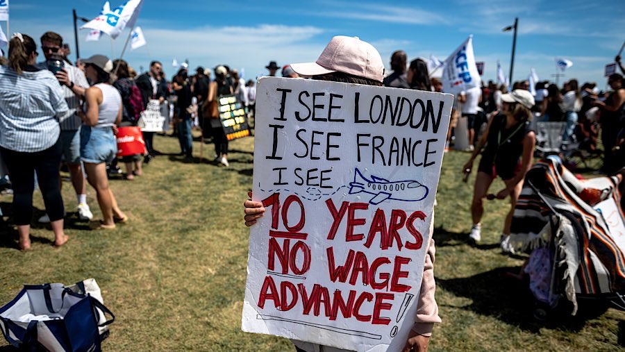 Penumpang melihat papan informasi penerbangan di Bandara Montreal-Pierre Elliott Trudeau, Kanada, Senin (18/8/2025). (Andrej Ivanov/Bloomberg)