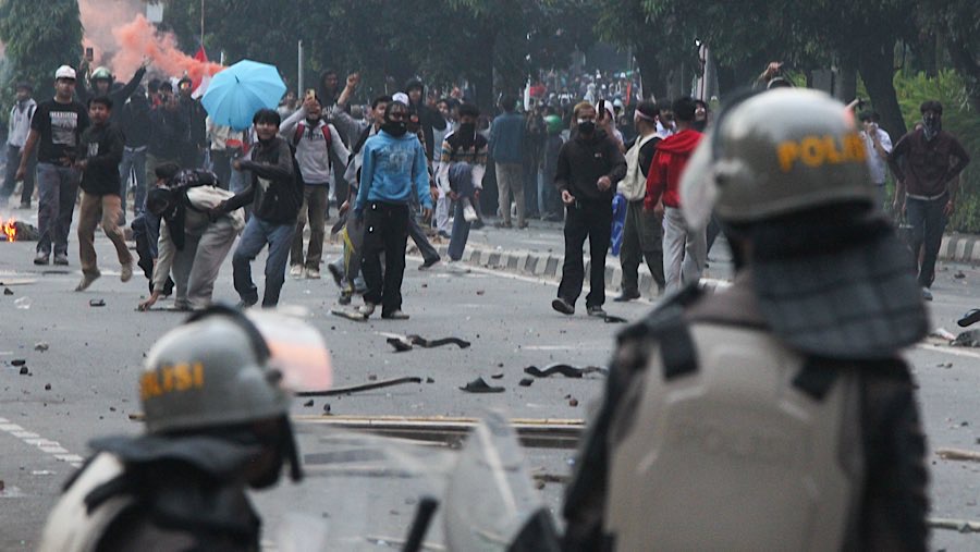 Polisi menembakkan gas air mata yang disambut dengan tembakan kembang api oleh sejumlah massa aksi. (Bloomberg Technoz/Andrean Kristianto)