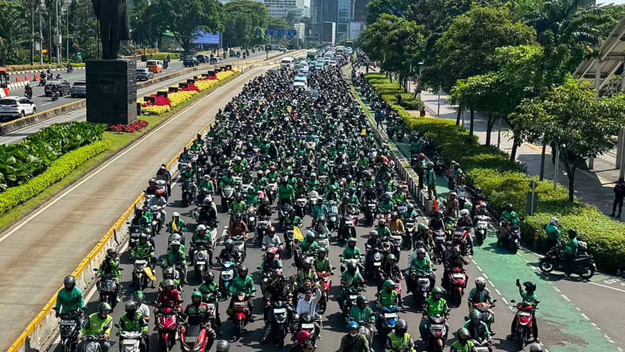 Sejumlah ojol mengiringi mobil ambulance jenazah Affan di Sudirman, Jakarta, Jumat (29/8/2025). (Bloomberg Technoz/Andrean Kristianto)
