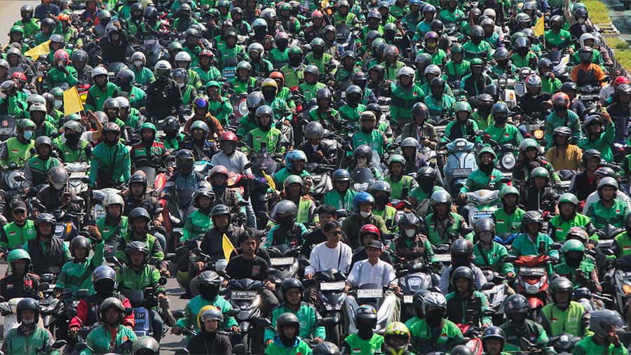Tamapk para ojol yang mayoritas berjaket hijau mengantarkan jenazah melalui jalan Jenderal Sudirman, Jakarta.. (Bloomberg Technoz/Andrean Kristianto)