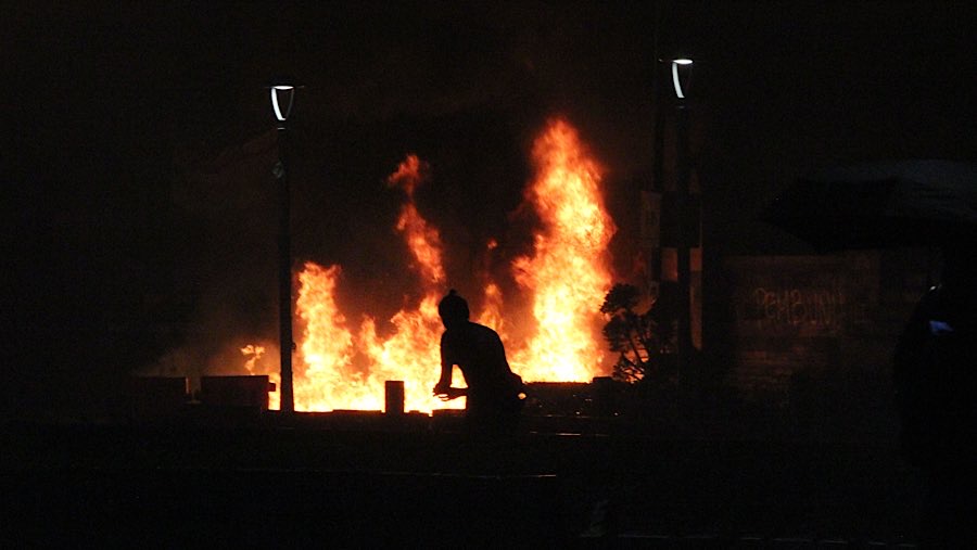 Massa juga membakar barier dan pagar pembatas jalan di depan Polda Metro Jaya. (Bloomberg Technoz/Andrean Kristianto)