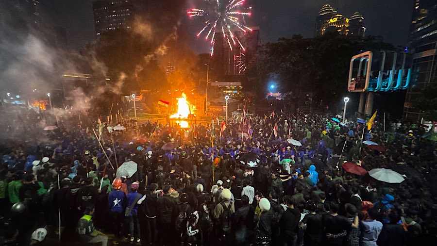 Massa aksi menyalakan kembang api yang diarahkan ke halaman Polda Metro Jaya, Jakarta, Jumat (29/8/2025). (Bloomberg Technoz/Andrean Kristianto)