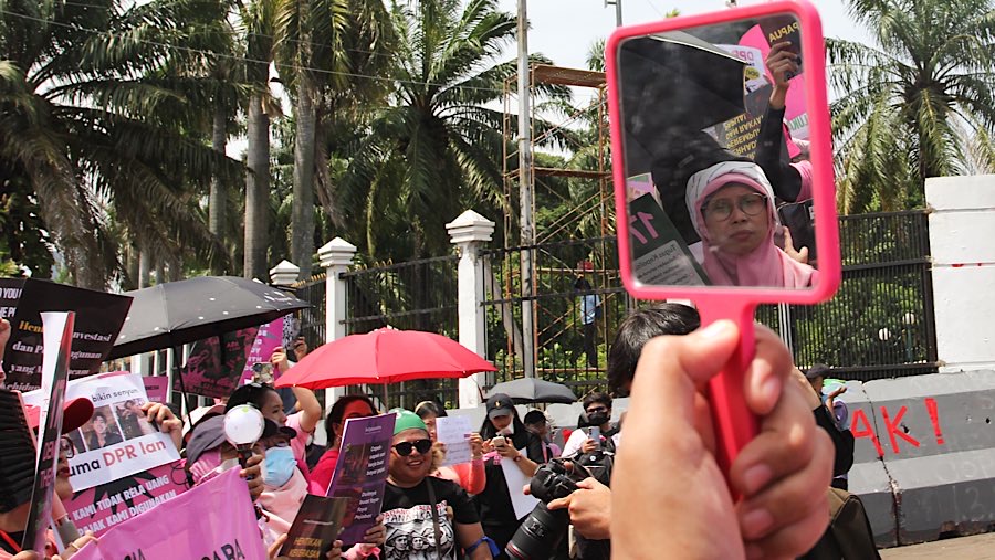 Peserta aksi yang didominasi perempuan mengenakan pakaian merah muda dan hitam. (Bloomberg Technoz/Andrean Kristianto)