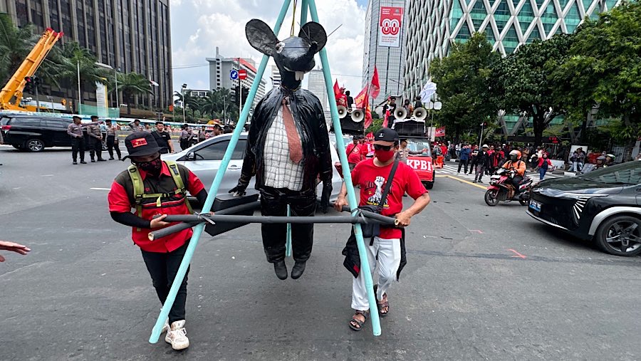 Dalam aksinya para buruh tersebut menbawa boneka menyerupai tikus yang memakai jas. (Bloomberg Technoz/Andrean Kristianto