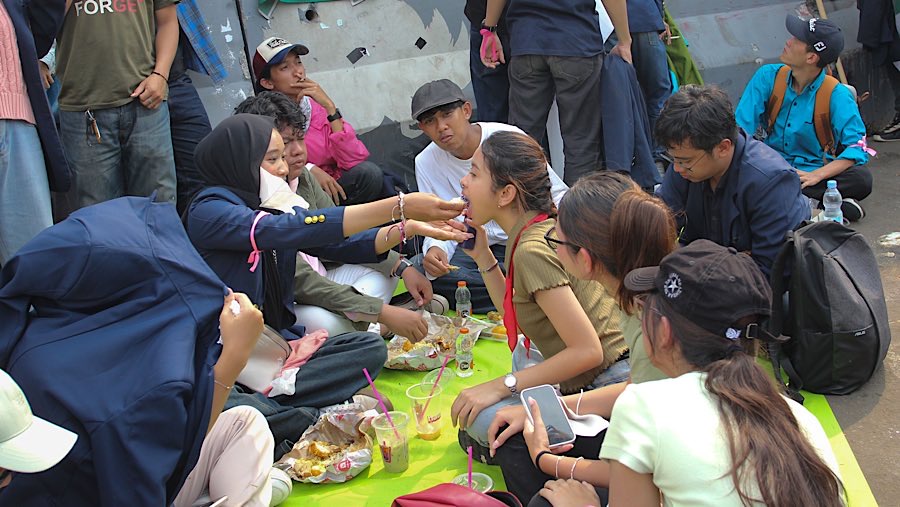 Massa melakukan aksi makan bersama, seolah menjadikan aksi ini benar-benar sebagai sebuah “piknik”. (Bloomberg Technoz/Andrean Kristianto).