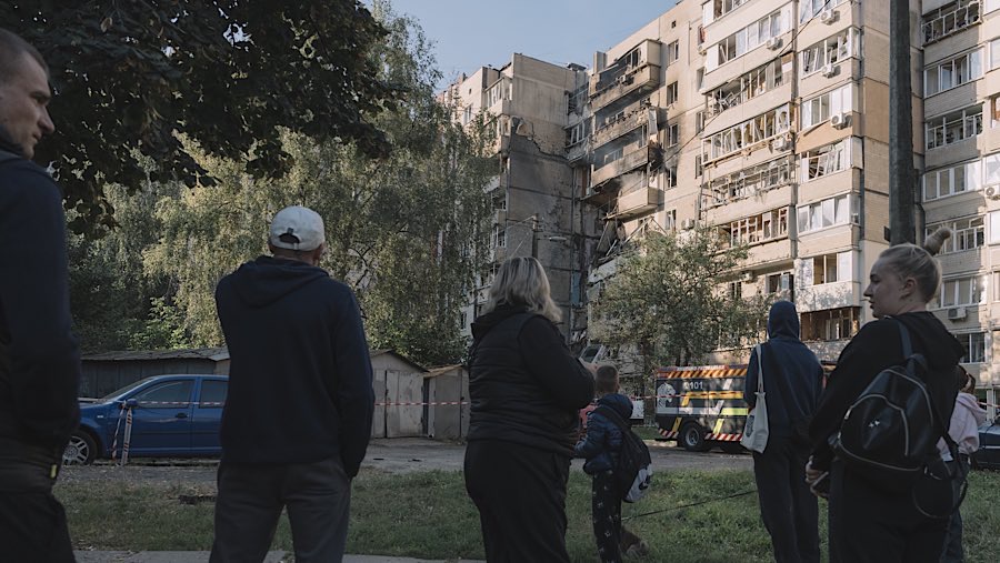 Warga melihat bangunan yang rusak akibat serangan udara Rusia di Kyiv, Ukraina, Minggu (7/9/2025). (Andrew Kravchenko/Bloomberg)