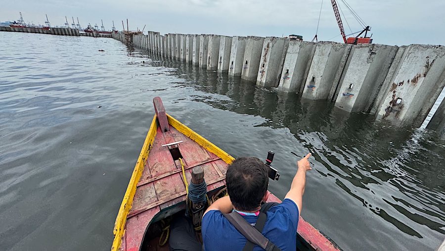 Seseorang berada di dekat tanggul beton yang berada di laut Cilincing, Jakarta Utara, Kamis (11/9/2025). (Bloomberg Technoz/Andrean Kristianto)
