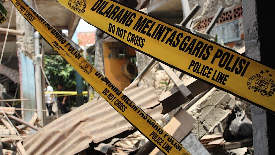 Untuk mensterilkan lokasi kejadian, aparat kepolisian masang garis polisi. (Bloomberg Technoz/Andrean Kristianto)