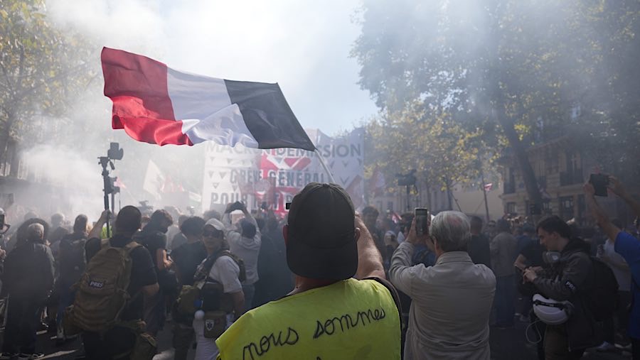 Seorang demonstran mengibarkan bendera Prancis dalam protes anti-penghematan di Paris, Prancis, Kamis (18/9/2025). (Nathan Laine/Bloomberg)