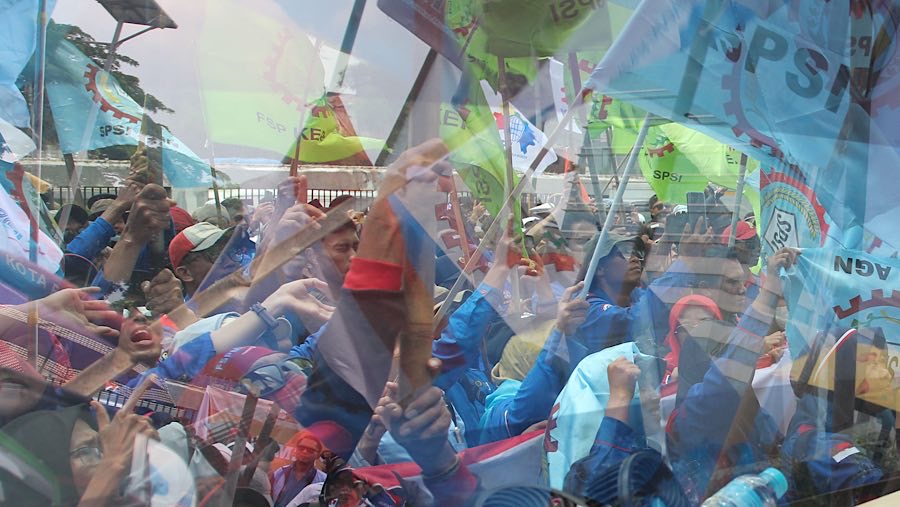 Dalam aksinya mereka menbawa spanduk dan bendera. (Bloomberg Technoz/Andrean Kristianto)