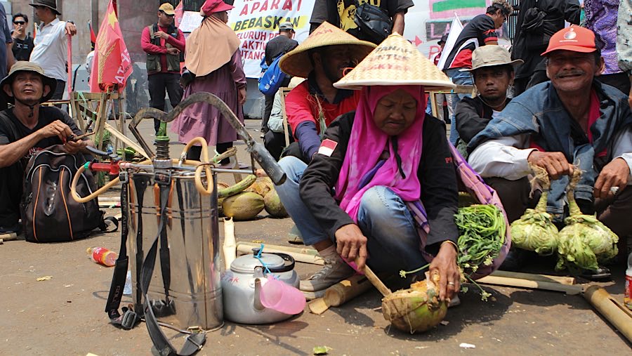 Mereka membawa atribut seperti bendera, spanduk, poster, serta hasil bumi.  (Bloomberg Technoz/Andrean Kristianto)