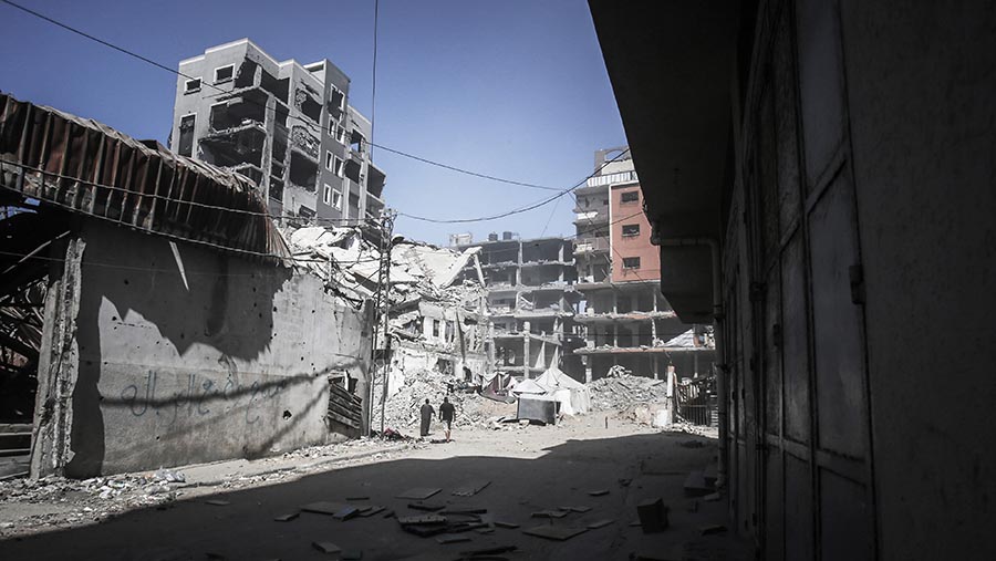 Warga Palestina berjalan melewati reruntuhan bangunan yang hancur di Kota Gaza, Gaza, Senin (29/9/2025). (Ahmad Salem/Bloomberg)