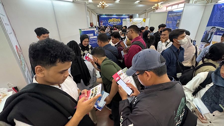 Pencari kerja mencari informasi lowongan pekerjaan saat bursa kerja di Jakarta, Rabu (1/10/2025). (Bloomberg Technoz/Andrean Kristianto)