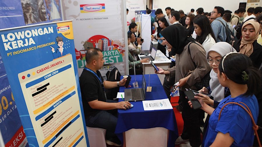 Pencari kerja mencari informasi lowongan pekerjaan saat bursa kerja di Jakarta, Rabu (1/10/2025). (Bloomberg Technoz/Andrean Kristianto)