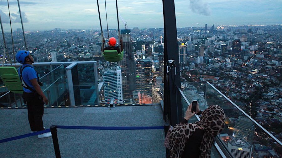 Selain berfoto pengunjung juga dapat bermain wahana yang berada di atas gedung tertinggi di Indonesi ini. (Bloomberg Technoz/ Andrean Kristianto)