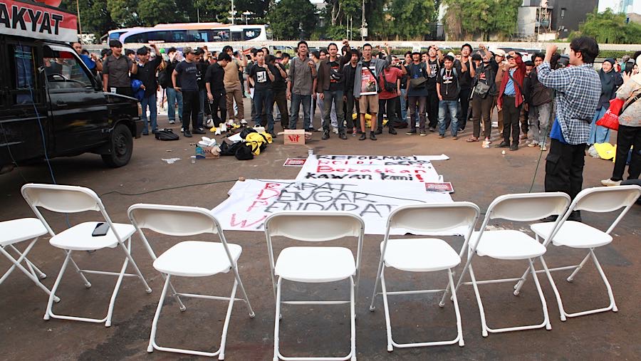 Aksi tersebut bertajuk ‘Rapat Dengar Pendapat Warga’ dengan menyiapkan tujuh kursi kosong yang disusun berjejer untuk para legislator. 