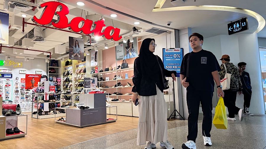 Pengunjung melintas di depan salah satu gerai PT Sepatu Bata Tbk (BATA), Jakarta, Kamis (9/10/2025). (Bloomberg Technoz/Andrean Kristianto)